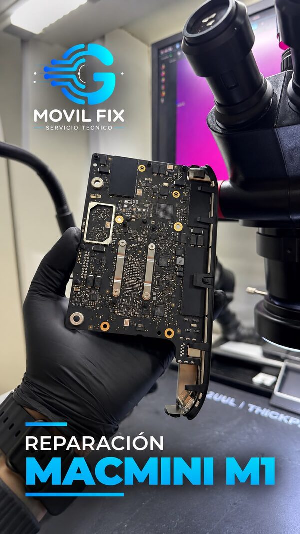 Técnico de MovilFixG sosteniendo la placa de un Mac mini M1 junto al microscopio